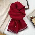Detail of dark red knit wool scarf with grey stripes and a gold decorative 'D' button - Burgundy