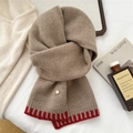 Detail of a brown wool knit scarf featuring a gold D badge and red accent blocks - Dark Coffee