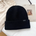 Primer plano de gorro de lana negra 100% con tejido de canalé y etiqueta negra sencilla - Negro