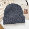 Close-up of dark grey 100% wool knit hat showing ribbed texture and quality wool label - Gray