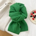 Close-up of green cable knit wool scarf texture with detail of a black woven label - 30x172cm / Green