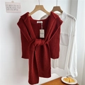 Close-up of deep red chunky knit shawl with vertical stripe texture and brand tags - Red