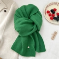 Close-up of vibrant green ribbed knit wool scarf featuring a premium silver metal charm - Green