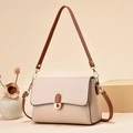 Chic cream leather crossbody bag with brown straps and gold buckle in minimalist setting - Khaki
