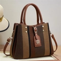 Macro shot of striped woven tote bag with brown faux leather trim and floral logo tag - Coffee