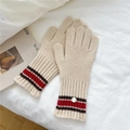 Detail von Strickhandschuhen mit rot-schwarzen Streifen und dekorativem Knopfverschluss - Einheitsgröße / Beige