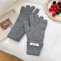 Detailed macro view of gray 100% wool knitted gloves featuring thickened wave-pattern cuffs - Gray