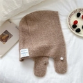 Detalle del pasamontañas de punto camel con una perla blanca y etiqueta de marca tejida - café