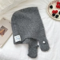 Detail of grey knitted balaclava hood featuring a pearl button and Winterwear label - Gray