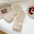 Detail of oat-beige knitted gloves featuring heart metal charm and textured cuff design - One Size / Cream