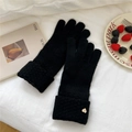 Detail of black knit winter glove featuring thick ribbed cuff and golden heart charm - One Size / Black