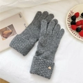 Detailed close-up of dark grey knitted gloves with gold heart charms and ribbed cuffs - One Size / Gray