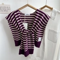 Macro view of purple and beige striped knit shawl with woven brand tag detail - Purple Striped