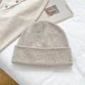 Detail of oatmeal flecked yarn knitted beanie showing thick rolled edge and soft texture - 100% Wool Speckled Beige