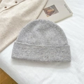 Close-up of gray speckled knit beanie texture with magazine and warm sweater backdrop - 100% Wool Speckled Light Grey