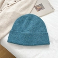 Close-up of blue knit beanie with snowflake texture on white fabric background - One Size / Lake Blue