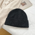 Detailed close-up of dark grey knitted beanie with white speckles on fabric - 100% Wool Speckled Black