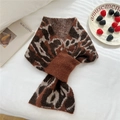Detail of leopard print knitted scarf with cross-through loop on soft white bedding - Brown Leopard