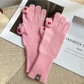 Detail of pink knitted gloves featuring flip finger design and red heart embroidery - Pink