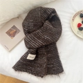 Soft brown knit scarf with grey stripes and brand tag on a warm aesthetic background - Striped Brown