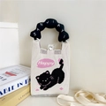 Détail du sac tricoté avec motif de chat et poignée nuage posé sur des livres - Style Chat Noir avec Poignée Noire