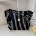 Gros plan sur un sac cabas en toile à rayures noires et blanches avec étiquette de marque - Rayé Beige