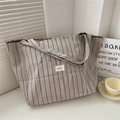 Détail du sac cabas en toile rayée avec étiquette tissée et larges poignées robustes - Rayures Beige Noires
