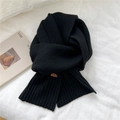 Solid black knitted winter scarf with a leather logo patch on a white textured background - 20cmx170cm / Black
