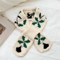 Close-up of a beige knitted scarf with abstract green floral patterns on white fabric - Beige (Lucky Clover)