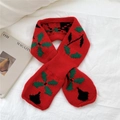 Close-up of red knit scarf with green holly leaf patterns on white fabric background - Red (Lucky Clover)