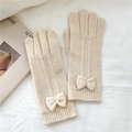 Détails de gants en tricot beige avec un nœud 3D sur un fond en lin doux et blanc - Taille unique / crème
