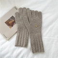 Detailed view of knitted winter gloves with rib cuffs and gold metal emblem on fabric - One Size / Beige Coffee