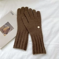 Close-up of coffee brown knitted gloves with ribbed cuffs and round metal tag detail - One Size / Brown