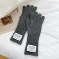 Detail of dark grey knitted wool gloves with a minimalist woven label on the wrist cuff - One Size / Dark Gray