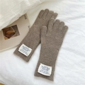 Detailed macro view of camel knit wool gloves with vertical ribbing and fabric label - One Size / Dark Camel