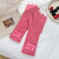 Detailed view of pink knitted mittens with ribbed texture and woven winterwear label - Full Finger / Pink