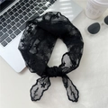 Dettaglio del foulard in pizzo nero con ricamo floreale su scrivania bianca - Pizzo Nero Floreale / Nero