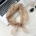 Dettaglio bandana in pizzo beige con ricamo Lucky accanto a occhiali da sole e caffè - Pizzo Cammello Floreale / Cammello