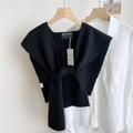Dettaglio di uno scialle in maglia nera con etichetta su un colletto di camicia bianca - Nero