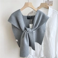 Dettaglio dello scialle in maglia grigia a coste con nodo su camicia di cotone bianco - Grigio