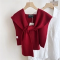 Dettaglio dello scialle in maglia rosso scuro con trama a coste e marchio visibile - Borgogna