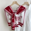 Close-up of knit shawl with red daisy patterns and decorative letter H embroidery - Red (Sunflower)