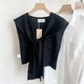 Dettaglio di uno scialle nero lavorato a maglia con lacci frontali e scollo a V - 44*100cm / Nero con trama a fiocco