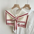 Détail du châle en tricot crème avec rayures rouges et nœud réglable sur le devant - Rayures Rouges et Beige