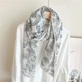 Dettaglio di sciarpa stropicciata con motivo paisley appesa a una gruccia di legno - 38*157cm / Paisley Bianco Latte