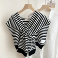 Close-up of black and white striped knitted shawl draped over a white shirt on a wooden hanger - Black & White Stripes