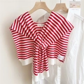 Detail shot of a red and white striped knitted shawl wrap on a wooden hanger - Red and White Striped