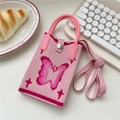 Dettaglio borsa porta cellulare rosa in maglia con farfalla e tracolla su scrivania bianca - Farfalla Colorata Rosa