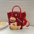 Detail der roten Strickhandtasche mit goldenem MONEY-Schriftzug und rundem Griff - Mittel / Weinrote Geldtasche (MONEY)