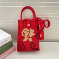 Dettaglio borsa in maglia rossa con carattere Fu dorato e morbida trama in lana tessuta - Nuvola di Fortuna Dorata Rossa